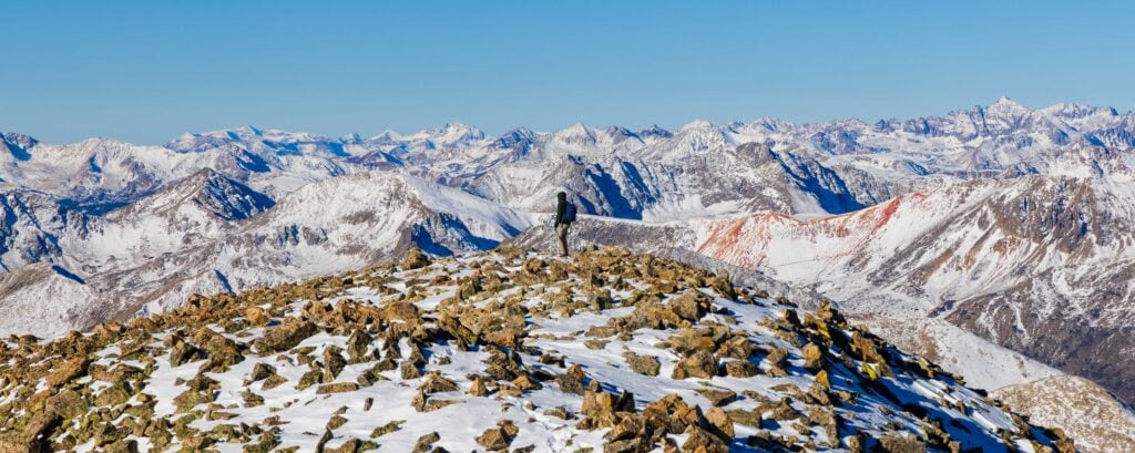 a hiker stands near the summit of la plata peak in colorado