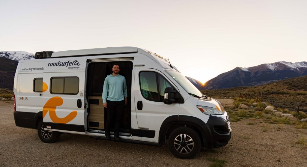 a travler stands in his road surfer camper van at a campground near twin lakes