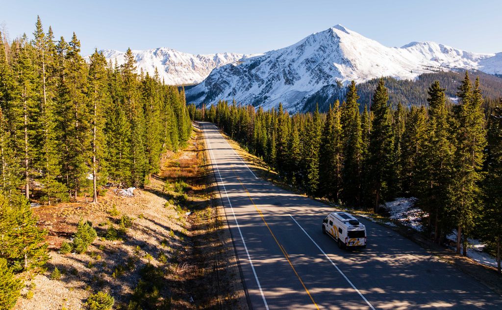 a mountain road with a camper van parked on the side