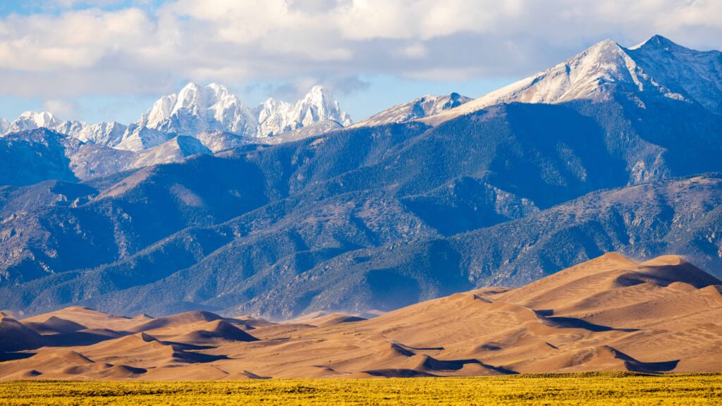 the great sand dunes in colorado with snow capped peaks of the sangre de cristo peaks