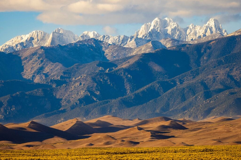 the great sand dunes in colorado with snow capped peaks of the sangre de cristo peaks