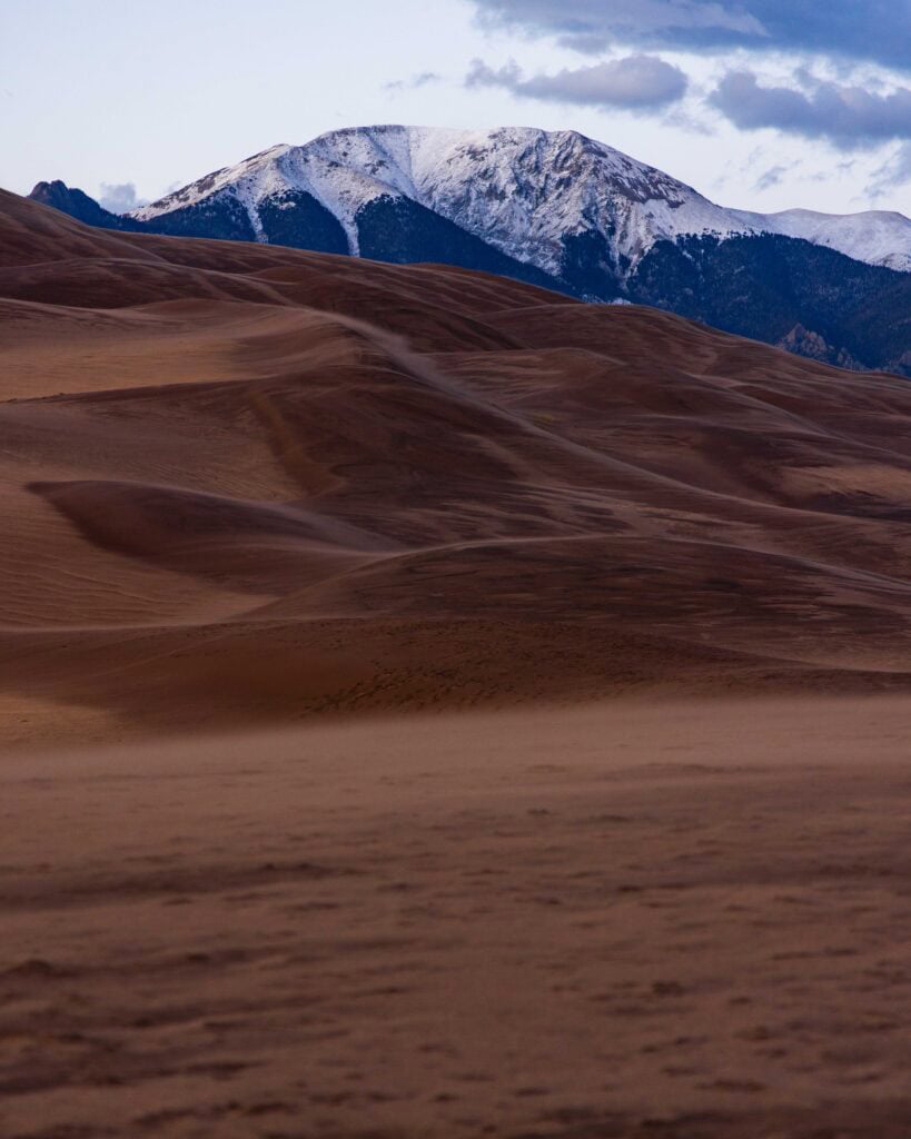 the great sand dunes in colorado with snow capped peaks of the mount herard