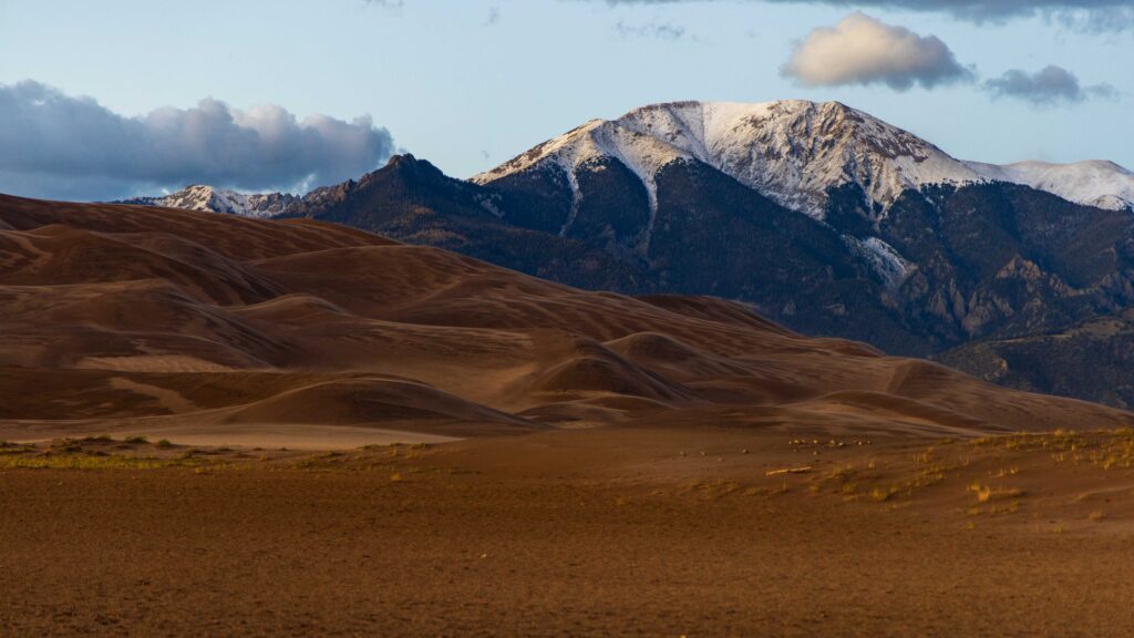 the great sand dunes in colorado with snow capped peaks of the sangre de cristo peaks
