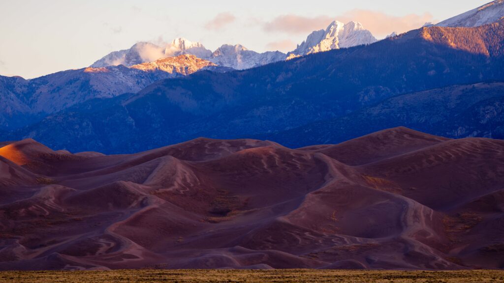 the great sand dunes in colorado with snow capped peaks of the sangre de cristo peaks