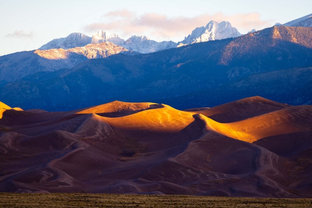 the great sand dunes in colorado with snow capped peaks of the sangre de cristo peaks