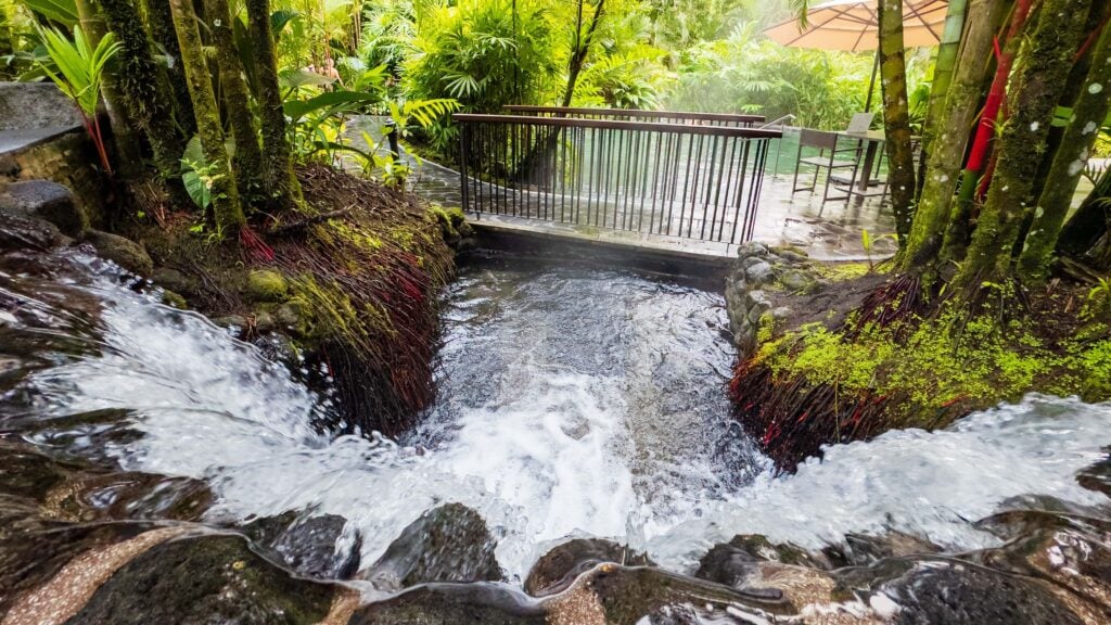 one of the pools at tabacon hot springs resort with a bridge